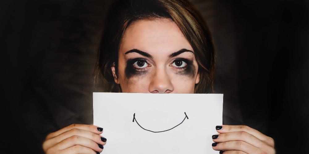 Woman holding picture of a smile over her face